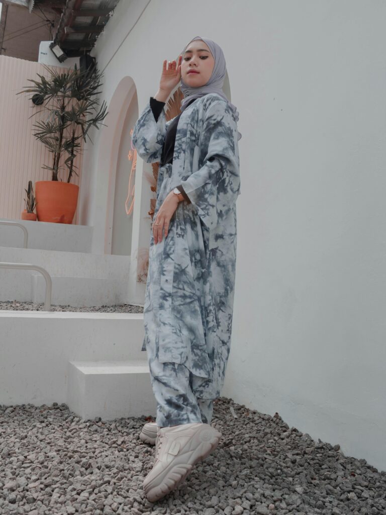 Elegant young woman in a stylish hijab, standing confidently outdoors.